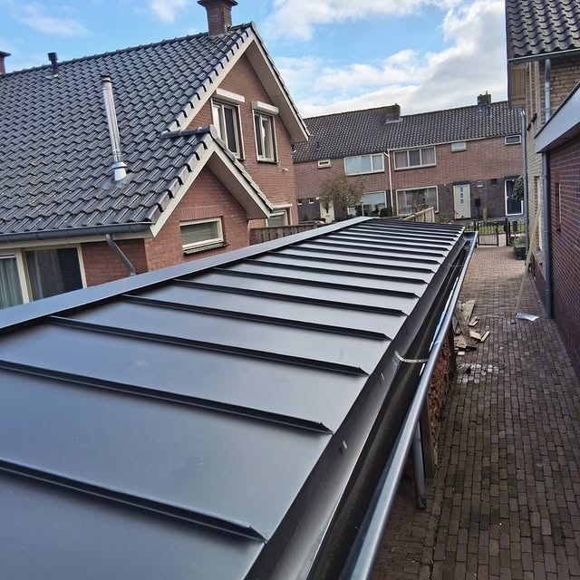 Mansardedak met glazen aanbouw in zink afgewerkt